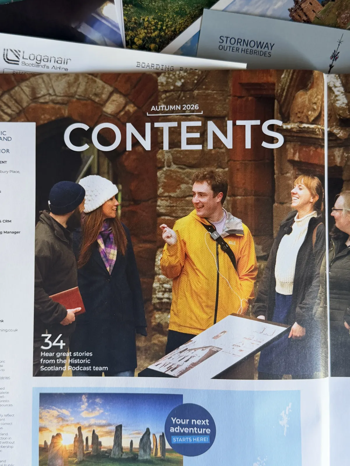 The magazine's contents spread: a man in a yellow jacket with a recorder slung across his chest talking to a group beside a stone archway, captioned 'Hear great stories from the Historic Scotland Podcast team'.