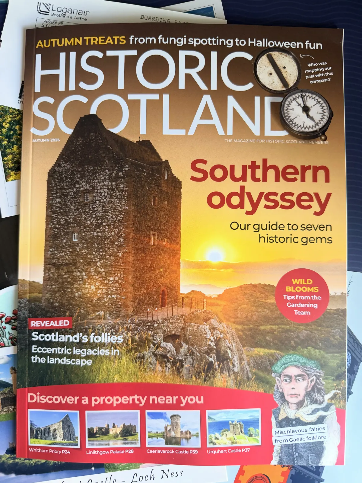 The Autumn 2026 issue of Historic Scotland, cover line 'Southern odyssey', a tower house lit by a low sun, resting on a pile of Loganair boarding passes and postcards.